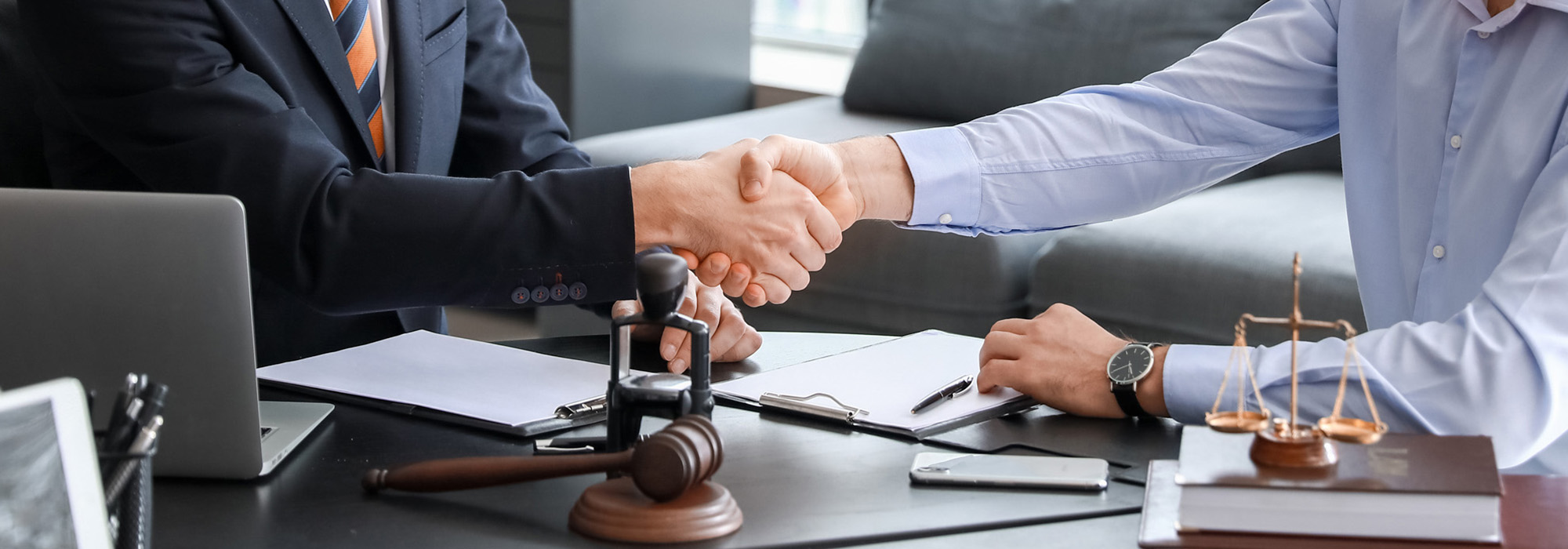 male lawyer with client shaking hands in office