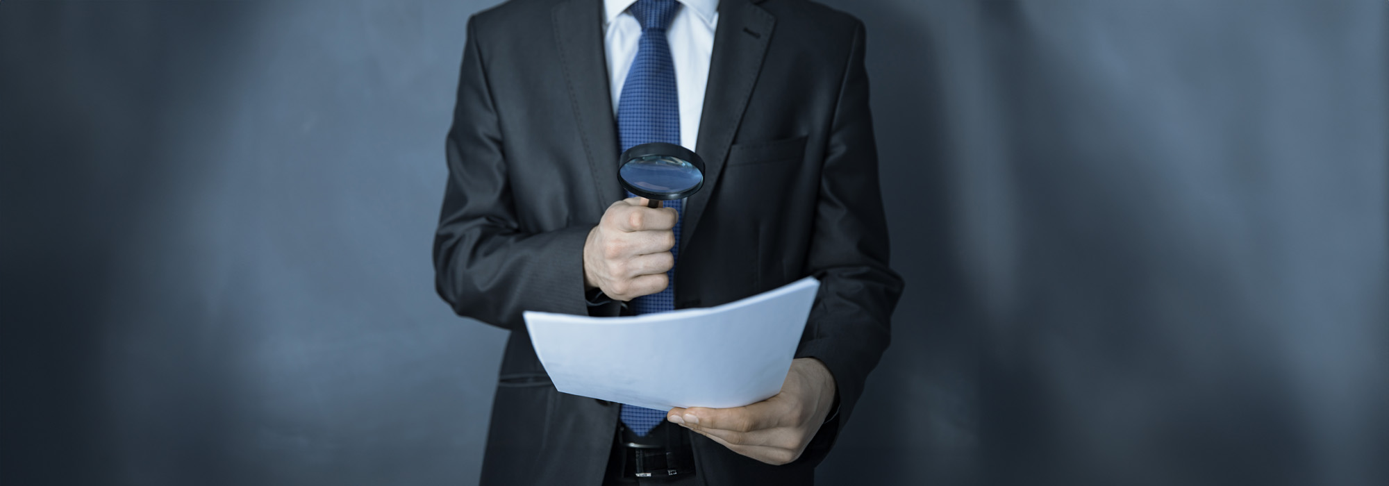 man hand magnifier and documenton dark background