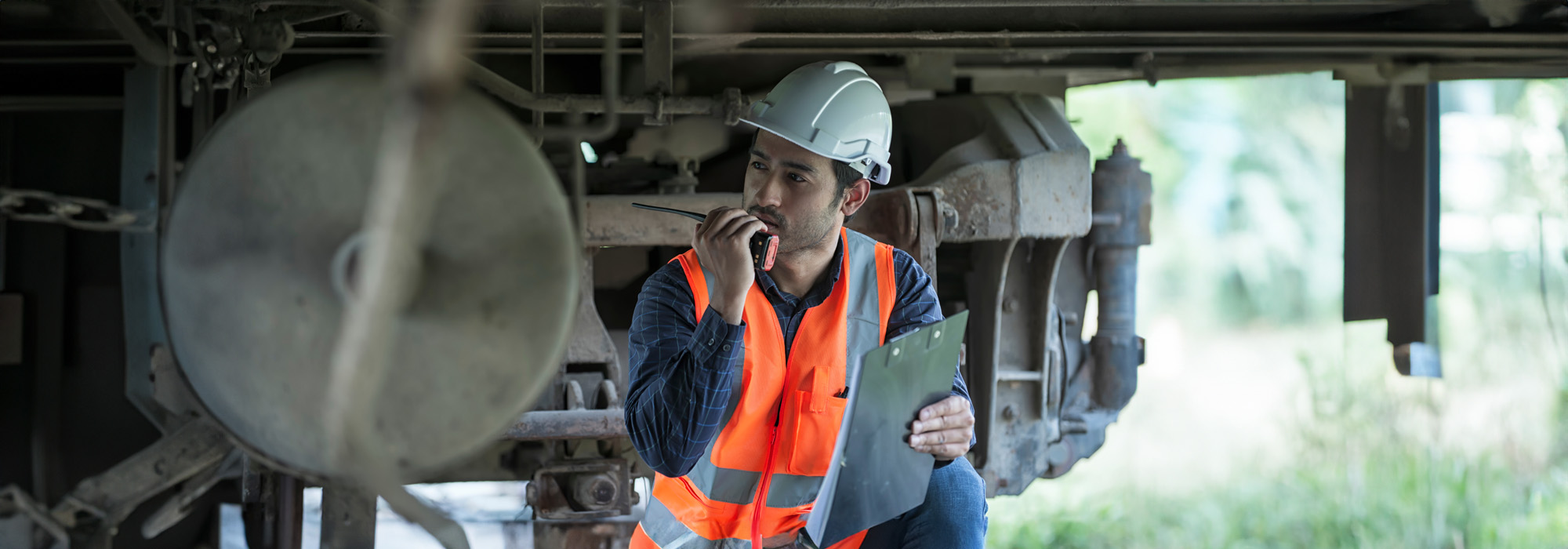 railroad worker checking up wheels and braking system of freight train