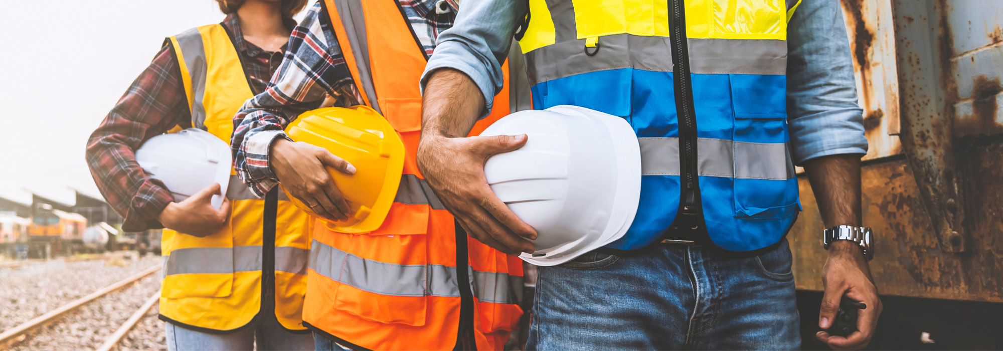 team engineer holding helmet standing in row on site work at train garage